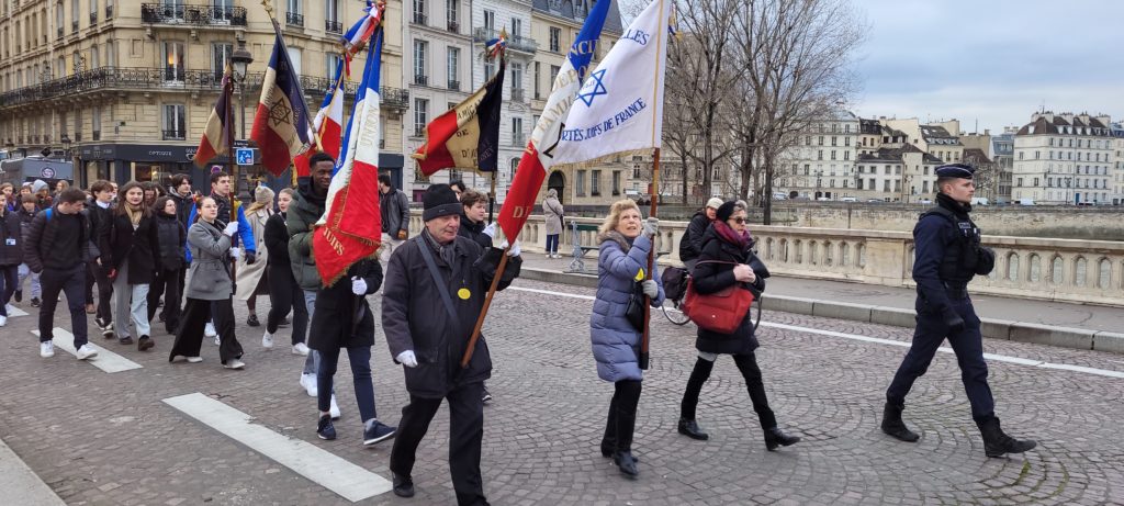Maurice Zynszajn, porte-drapeau de l'Amicale des Anciens Internés, Déportés et Familles du Camp de Drancy traverse la Seine en direction du Mémorial de la Shoah à l'occasion des cérémonies du 27 Janvier 2023.